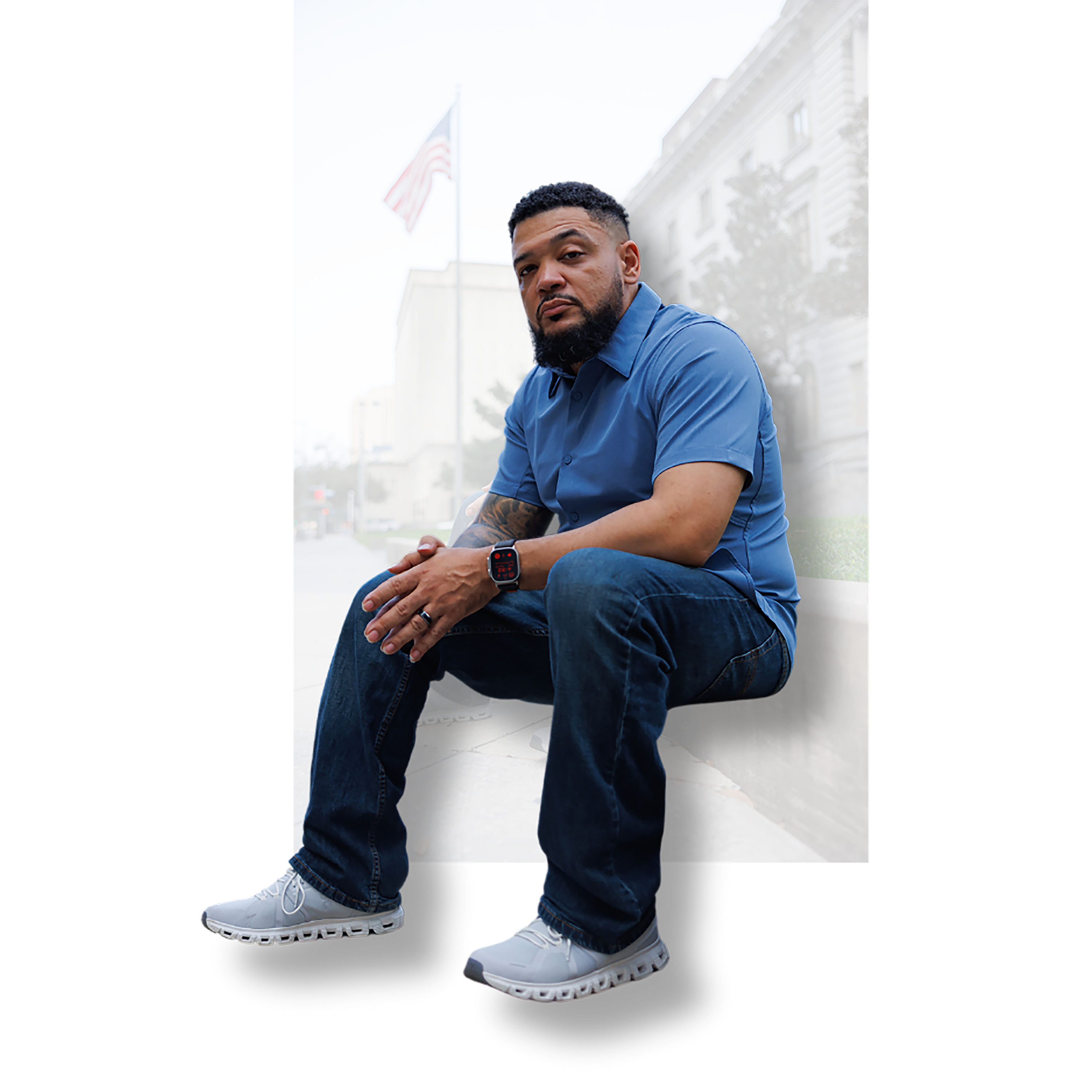 VNCC founder, DP, seated in front of a building with american flag in the background